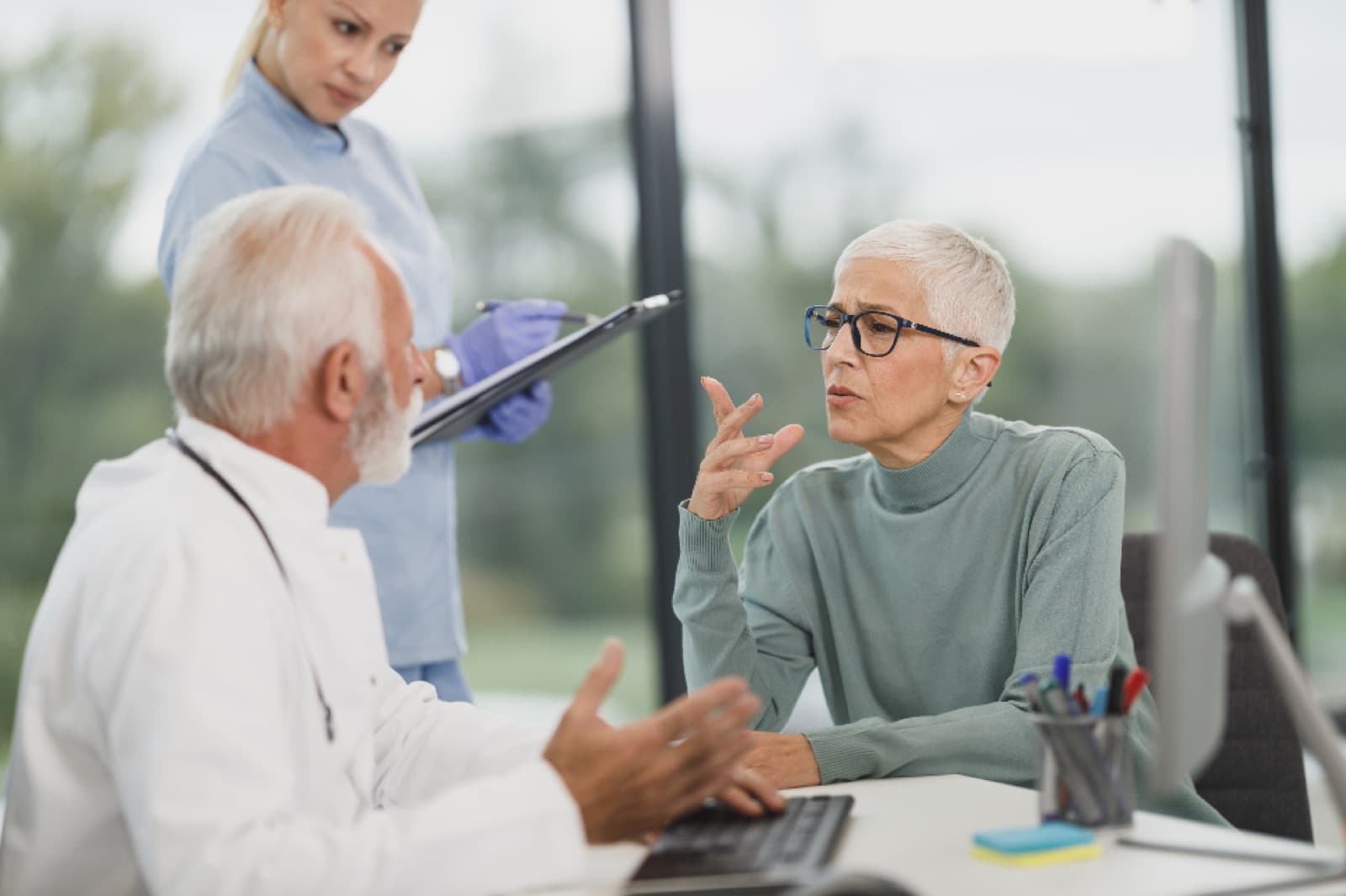 A doctor and patient talking across a desk in a modern clinic